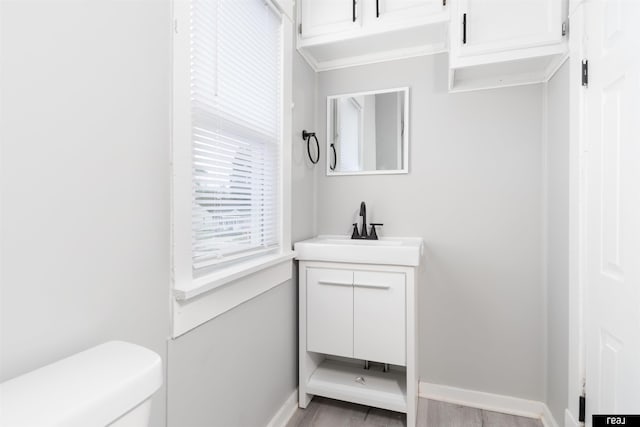 6935 Binney St, Omaha, NE 68104 - bathroom featuring vanity, toilet, baseboards, and wood finished floors