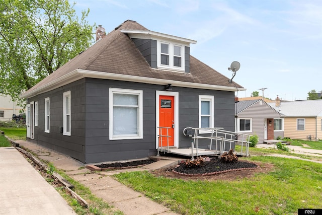 6935 Binney St, Omaha, NE 68104 - view of front of house with a chimney, a wooden deck, roof with shingles, and a front lawn