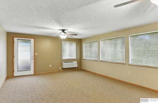 2417 Fairway Dr, Fremont, NE 68025 - spare room with ceiling fan, baseboards, a wall mounted air conditioner, a textured ceiling, and light colored carpet