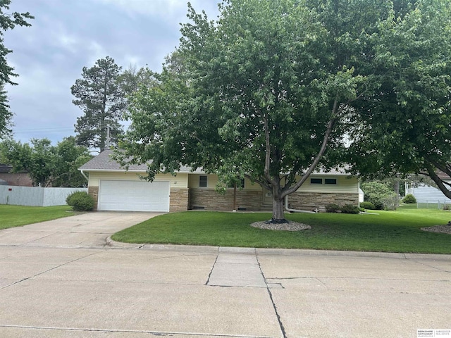 2417 Fairway Dr, Fremont, NE 68025 - obstructed view of property featuring concrete driveway, an attached garage, and stone siding