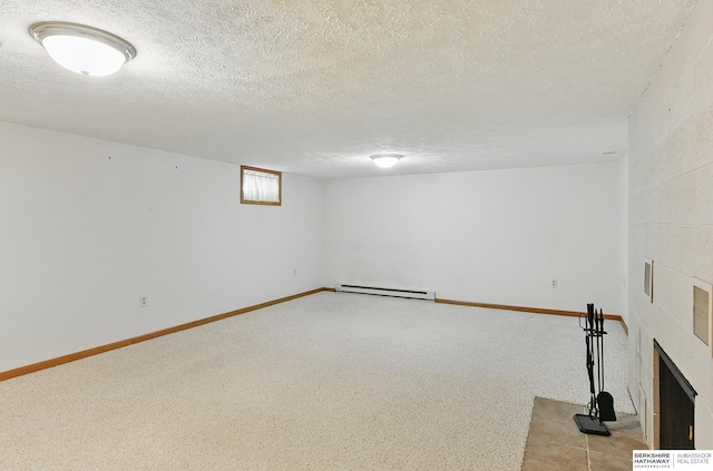2417 Fairway Dr, Fremont, NE 68025 - basement featuring a baseboard radiator, light carpet, a textured ceiling, a tiled fireplace, and baseboards