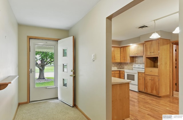 2417 Fairway Dr, Fremont, NE 68025 - kitchen with white electric stove, decorative backsplash, light countertops, baseboards, and decorative light fixtures