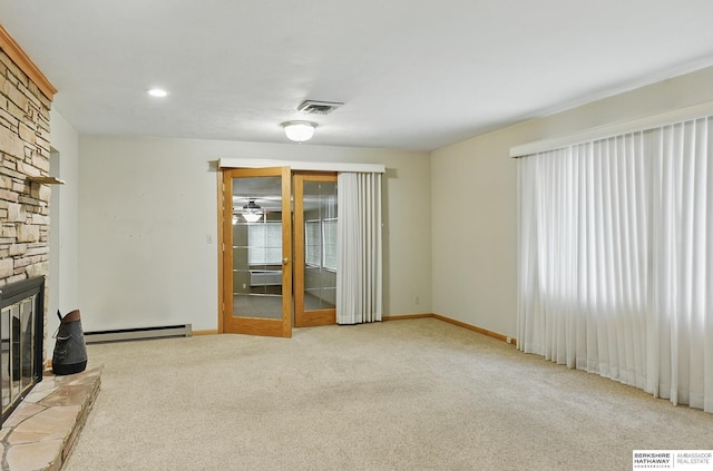2417 Fairway Dr, Fremont, NE 68025 - unfurnished living room featuring a baseboard heating unit, a stone fireplace, carpet floors, and baseboards