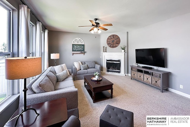 18914 C St, Omaha, NE 68130 - carpeted living area with a ceiling fan, a fireplace, and baseboards