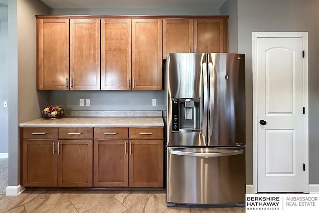 18914 C St, Omaha, NE 68130 - kitchen featuring stainless steel fridge with ice dispenser, brown cabinets, light countertops, and baseboards