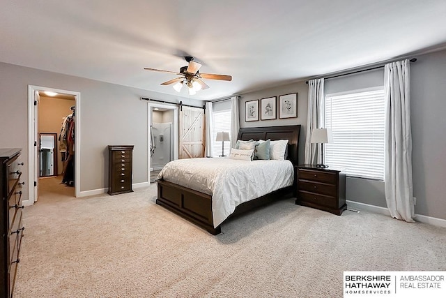 18914 C St, Omaha, NE 68130 - bedroom featuring baseboards, light carpet, a spacious closet, ceiling fan, and connected bathroom