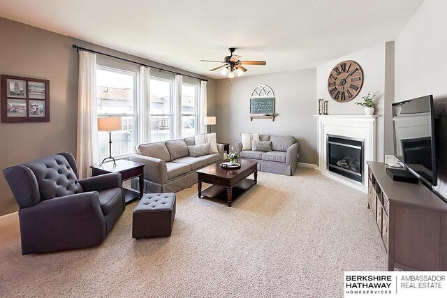 18914 C St, Omaha, NE 68130 - carpeted living area featuring a ceiling fan, a glass covered fireplace, and baseboards
