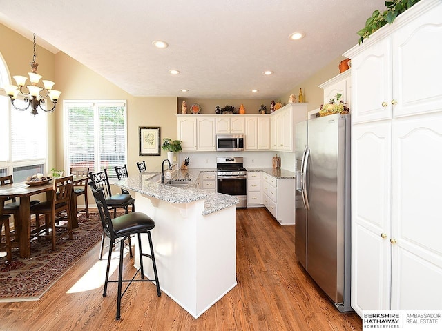 5103 N 140th St, Omaha, NE 68164 - kitchen with stainless steel appliances, a peninsula, a chandelier, a breakfast bar area, and recessed lighting