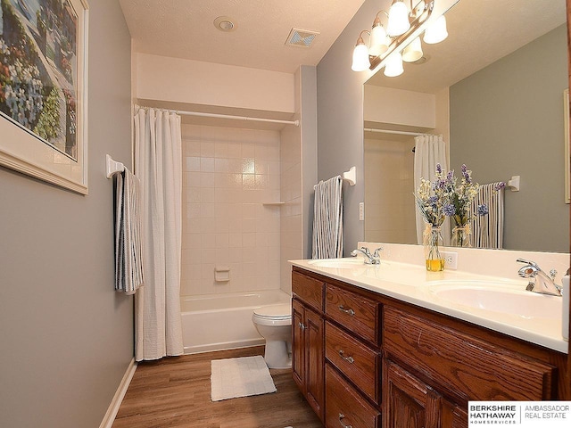 5103 N 140th St, Omaha, NE 68164 - bathroom featuring wood finished floors, double vanity, toilet, shower / bath combo with shower curtain, and a chandelier