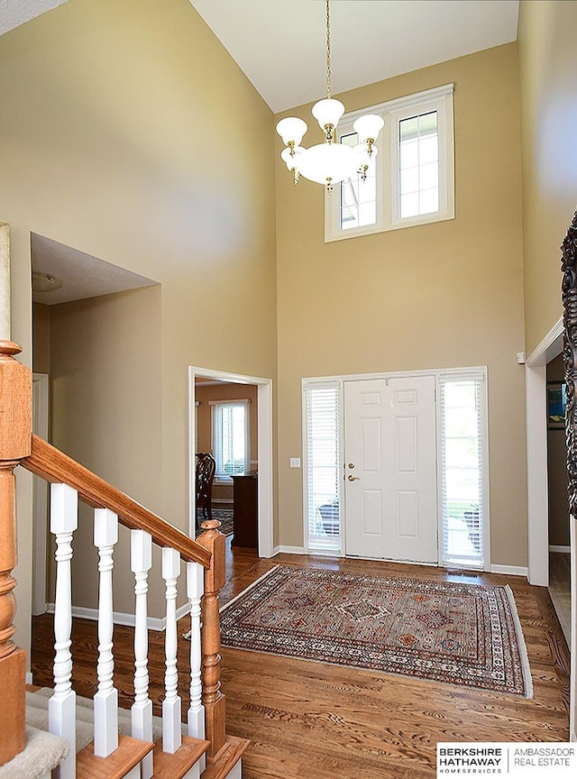 5103 N 140th St, Omaha, NE 68164 - foyer featuring high vaulted ceiling, a chandelier, wood finished floors, baseboards, and stairs
