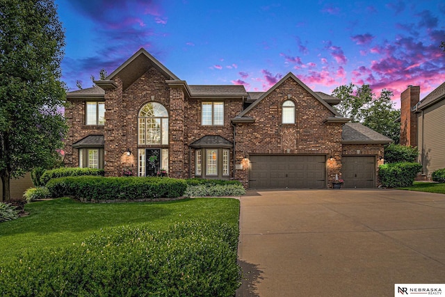 2221 S 181st Cir, Omaha, NE 68130 - view of front of house with concrete driveway, a lawn, brick siding, an attached garage, and a shingled roof