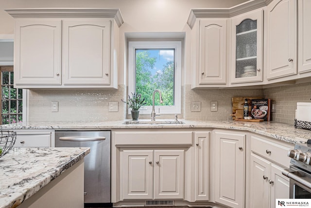 2221 S 181st Cir, Omaha, NE 68130 - kitchen with stainless steel appliances, tasteful backsplash, glass insert cabinets, light stone counters, and white cabinetry