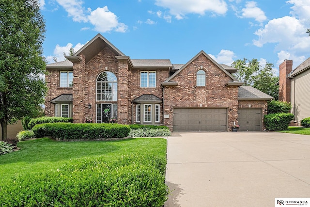 2221 S 181st Cir, Omaha, NE 68130 - view of front of property featuring driveway, brick siding, a front yard, and roof with shingles