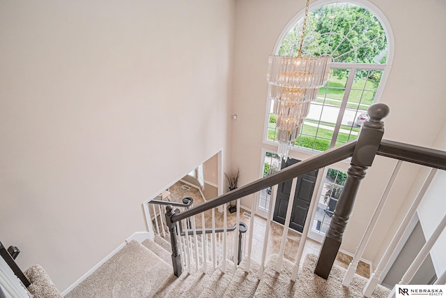 2221 S 181st Cir, Omaha, NE 68130 - staircase featuring a chandelier, a high ceiling, and carpet flooring