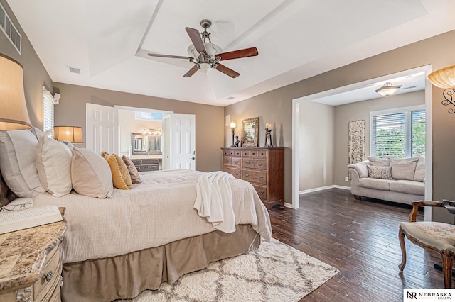 2221 S 181st Cir, Omaha, NE 68130 - bedroom featuring a raised ceiling, dark wood-style flooring, ensuite bath, and a ceiling fan