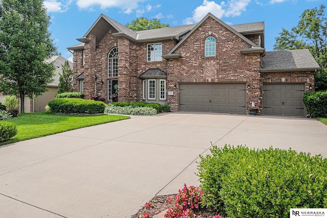 2221 S 181st Cir, Omaha, NE 68130 - traditional-style home featuring brick siding, roof with shingles, concrete driveway, a front lawn, and an attached garage