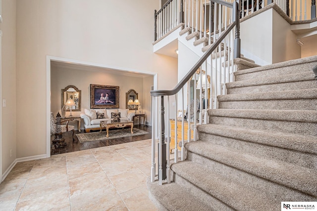 2221 S 181st Cir, Omaha, NE 68130 - stairs featuring a towering ceiling and baseboards
