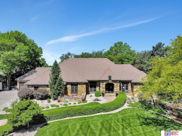 6602 Pheasant Run Pl, Lincoln, NE 68516 - view of front facade with french doors, stone siding, a tile roof, and a front lawn