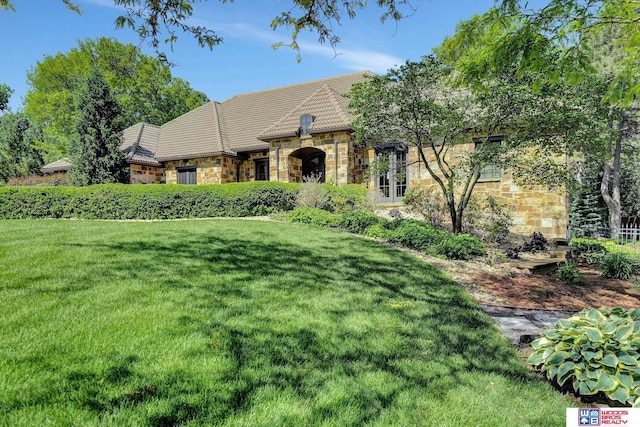 6602 Pheasant Run Pl, Lincoln, NE 68516 - view of front facade featuring stone siding, a front lawn, and a tiled roof