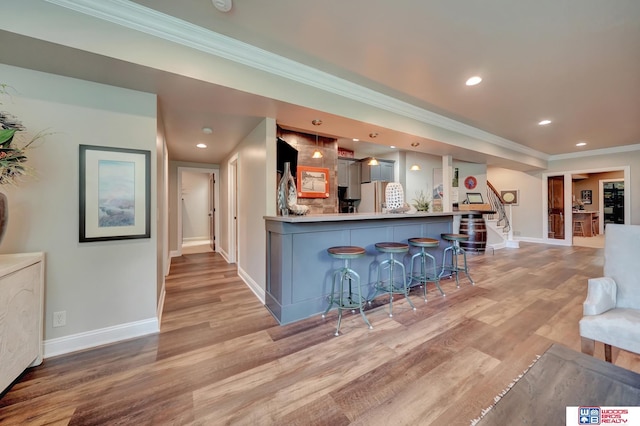 6602 Pheasant Run Pl, Lincoln, NE 68516 - kitchen with freestanding refrigerator, a breakfast bar, ornamental molding, baseboards, and light wood-type flooring