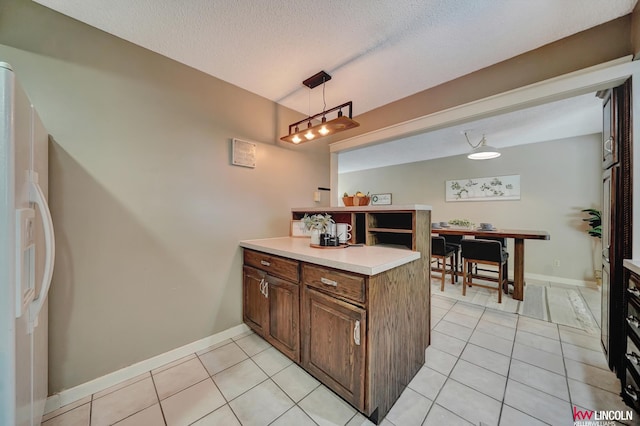 430 N 86th St, Lincoln, NE 68505 - kitchen featuring white refrigerator with ice dispenser, light tile patterned floors, a peninsula, light countertops, and a textured ceiling