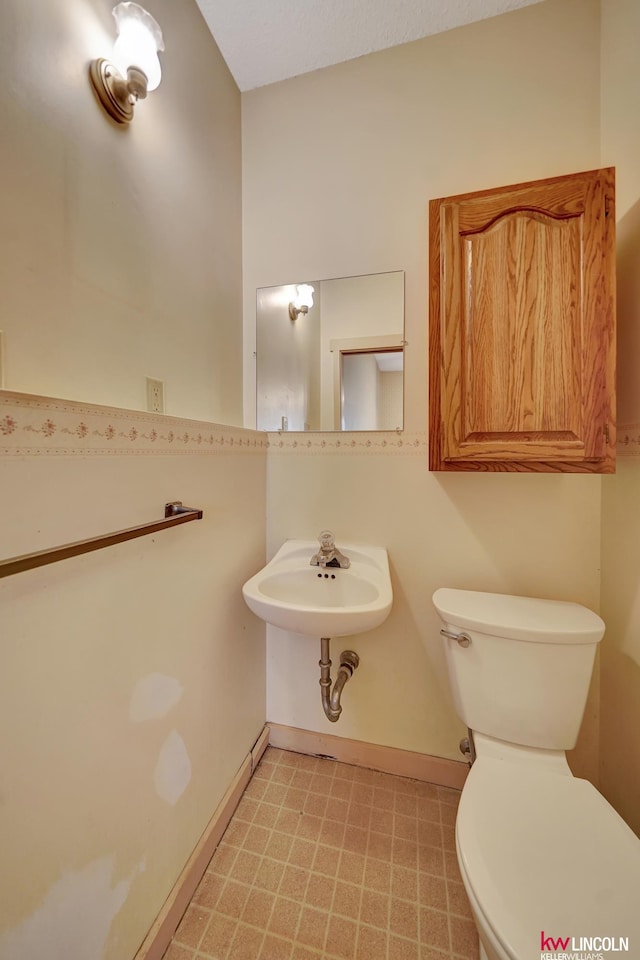 430 N 86th St, Lincoln, NE 68505 - half bath with toilet, baseboards, a sink, and tile patterned floors
