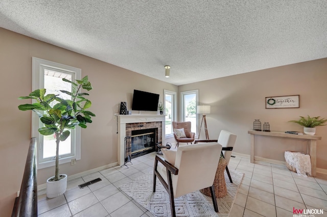 430 N 86th St, Lincoln, NE 68505 - living room featuring healthy amount of natural light, light tile patterned floors, a fireplace, a textured ceiling, and baseboards