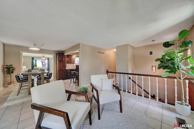 430 N 86th St, Lincoln, NE 68505 - living area with light tile patterned floors, an upstairs landing, a textured ceiling, and baseboards
