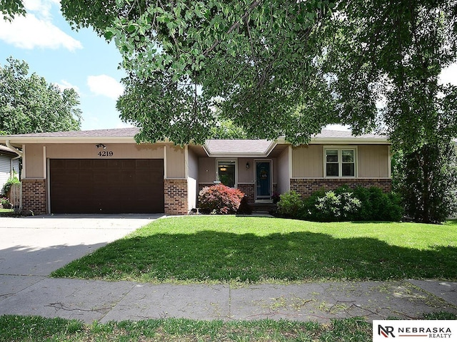 4219 Browning St, Lincoln, NE 68516 - ranch-style home featuring brick siding, a garage, a front lawn, and concrete driveway