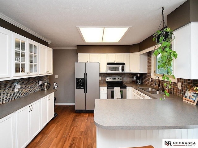4219 Browning St, Lincoln, NE 68516 - kitchen featuring stainless steel appliances, a sink, tasteful backsplash, glass insert cabinets, and ornamental molding
