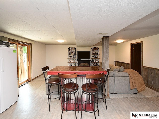 4219 Browning St, Lincoln, NE 68516 - dining space featuring light wood-style flooring, a wainscoted wall, and wooden walls