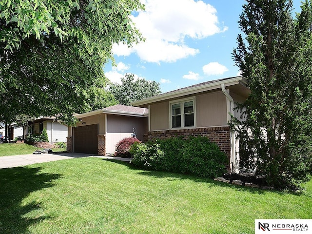4219 Browning St, Lincoln, NE 68516 - view of front facade featuring brick siding, a front lawn, an attached garage, and concrete driveway