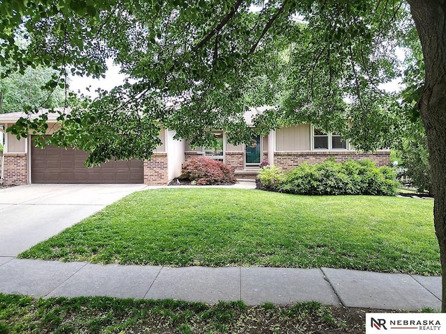 4219 Browning St, Lincoln, NE 68516 - view of property hidden behind natural elements with brick siding, an attached garage, concrete driveway, and a front lawn
