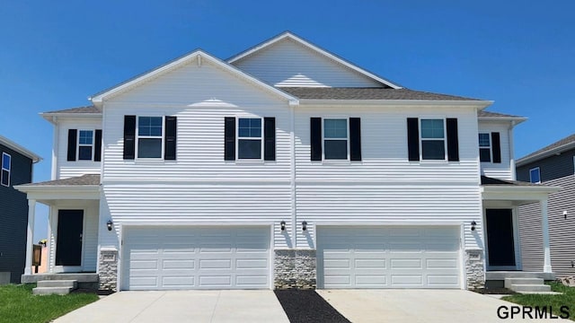 7814 N 169th St, Bennington, NE 68007 - view of front of home with driveway, an attached garage, and stone siding