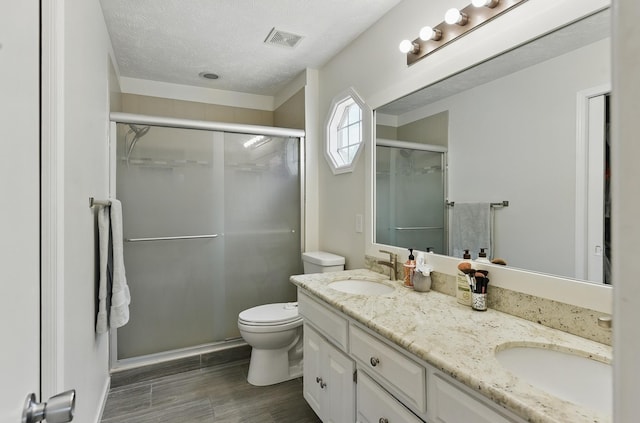 4019 N 147th St, Omaha, NE 68116 - full bath featuring double vanity, a shower stall, toilet, a textured ceiling, and wood finished floors