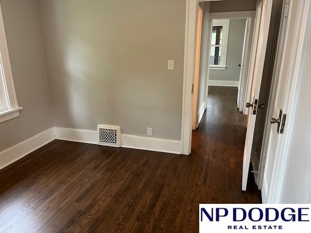 1406 S 55th St, Omaha, NE 68106 - unfurnished room featuring baseboards and dark wood finished floors