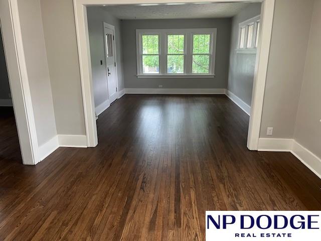 1406 S 55th St, Omaha, NE 68106 - spare room with dark wood finished floors and baseboards