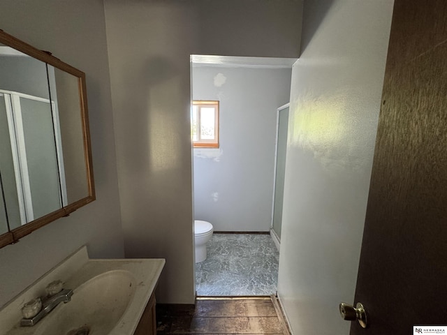 204 E York Ave, Dewitt, NE 68341 - bathroom with a shower stall, toilet, vanity, baseboards, and stone finish flooring