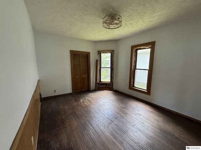 204 E York Ave, Dewitt, NE 68341 - spare room with dark wood-type flooring, a textured ceiling, and baseboards
