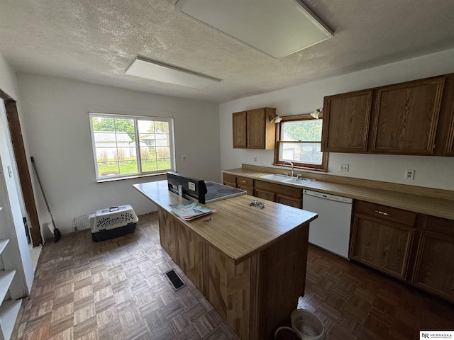 204 E York Ave, Dewitt, NE 68341 - kitchen with white dishwasher, a sink, a kitchen island, a textured ceiling, and butcher block countertops
