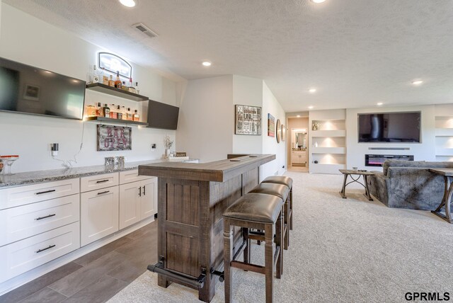 18403 Greenleaf St, Omaha, NE 68136 - kitchen with recessed lighting, white cabinetry, open shelves, a textured ceiling, and light stone countertops