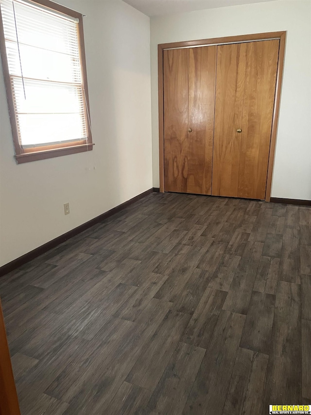 608 N 16th St, Nebraska City, NE 68410 - unfurnished bedroom with dark wood-style floors, a closet, and baseboards