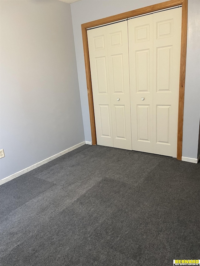608 N 16th St, Nebraska City, NE 68410 - unfurnished bedroom with dark carpet, baseboards, and a closet