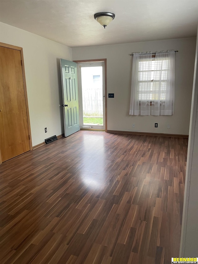 608 N 16th St, Nebraska City, NE 68410 - unfurnished living room with plenty of natural light, dark wood-style floors, and baseboards