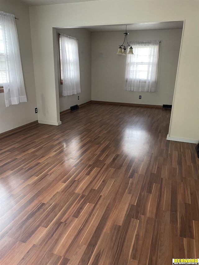 608 N 16th St, Nebraska City, NE 68410 - empty room with a chandelier, dark wood-type flooring, and baseboards
