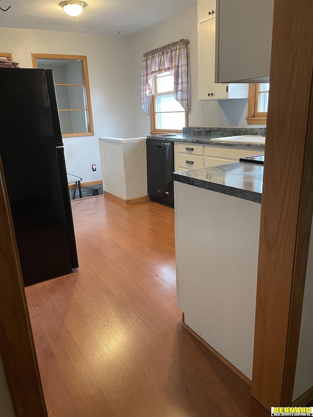 608 N 16th St, Nebraska City, NE 68410 - kitchen featuring black appliances, white cabinetry, light wood-type flooring, dark countertops, and a sink