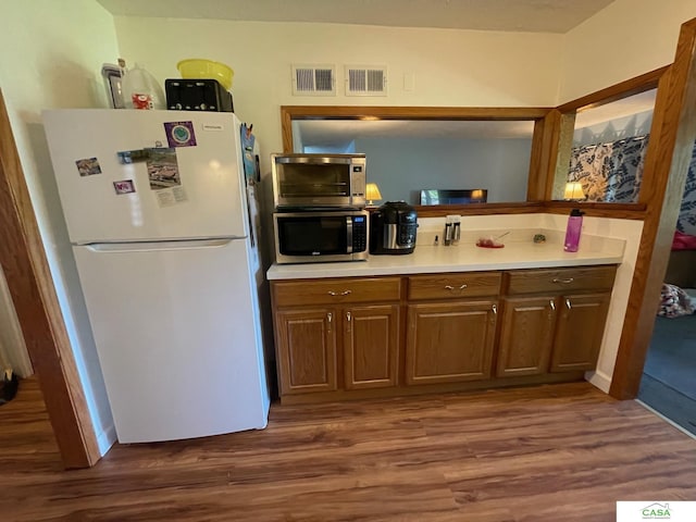 5427 W Hughes St, Lincoln, NE 68524 - kitchen with freestanding refrigerator, stainless steel microwave, and dark wood-style flooring
