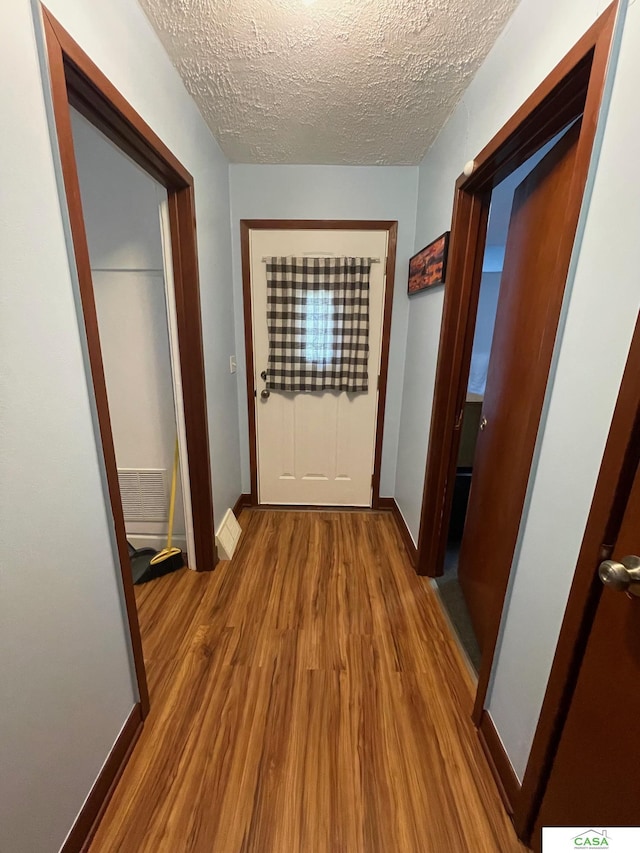 5427 W Hughes St, Lincoln, NE 68524 - hall with wood finished floors, a textured ceiling, and baseboards