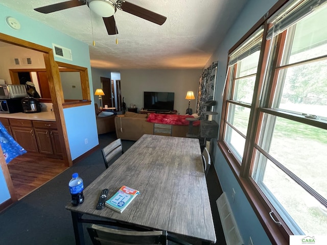 5427 W Hughes St, Lincoln, NE 68524 - dining space featuring a textured ceiling, a ceiling fan, and wood finished floors