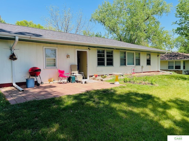 5427 W Hughes St, Lincoln, NE 68524 - rear view of house with a lawn, a patio, and a shingled roof